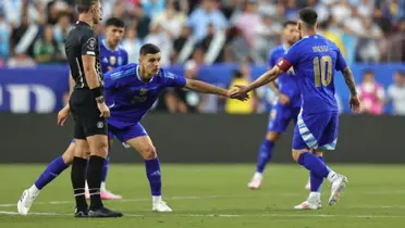 Carboni y Lionel Messi tocan sus manos.